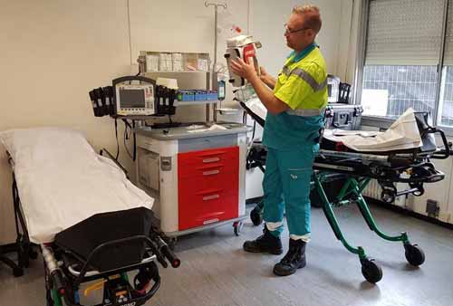 Een ambulancemedewerker van Witte Kruis evenementenzorg in de EHBO post bij de crashcar